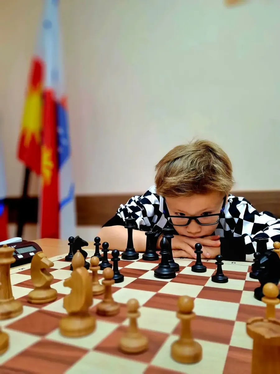 Ученик обдумывает ход за шахматной доской