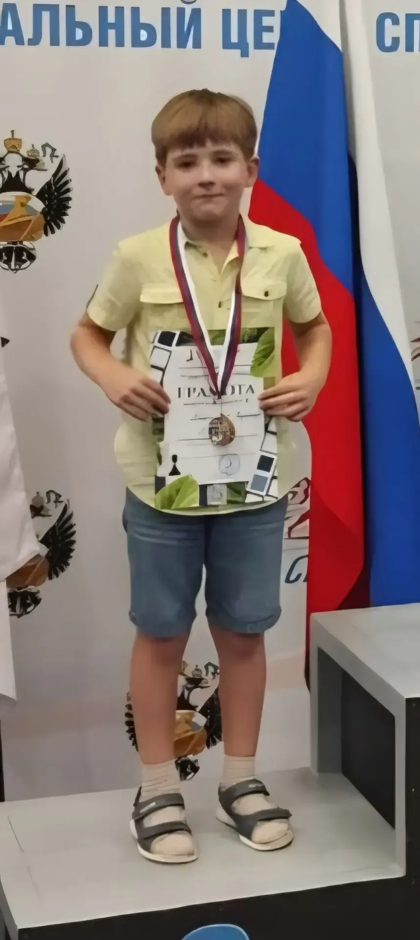 Ученик с медалью и грамотой на пьедестале