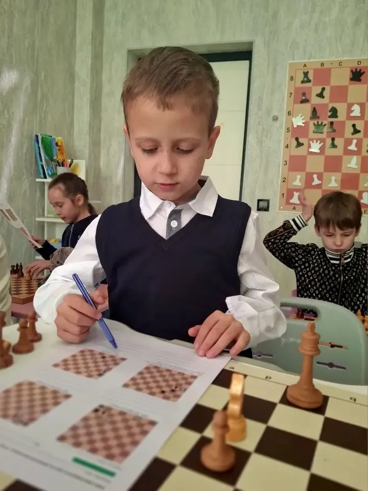 Ребёнок решает шахматные задания на занятии
